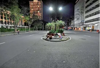  ?? — AFP photos ?? Street dwellers sleep on an island along a road serving as their temporary shelter in Manila.