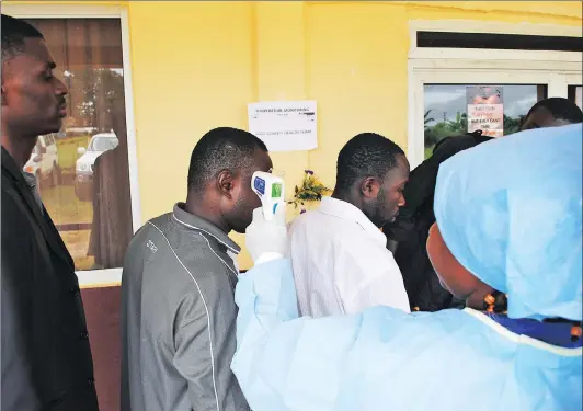  ?? Picture: REUTERS ?? BRINGING RELIEF: A health worker takes the temperatur­e of people at a news conference on the opening of a new Ebola clinic, outside Monrovia, Liberia, in 2014.