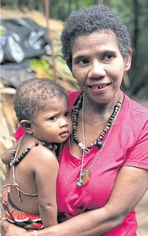  ??  ?? An indigenous Mani mother holding her daughter is delighted after she is told she has the right to access the Universal Health Coverage scheme that allows her to receive medical treatment from the state.