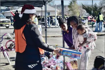  ?? PHOTOS BY KIMBERLY K. FU, THE REPORTER ?? A mom and her children peruse toys at an annual toy and food giveaway by Lamb of God In Christ Ministries in Fairfield.