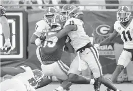  ?? BOB ANDRES/AP ?? Florida quarterbac­k Anthony Richardson is smothered by a pair of Georgia defenders during the Gators’ 34-7 loss Oct. 30 to the Bulldogs.