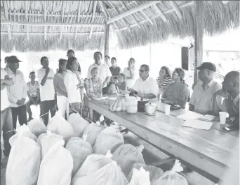  ?? (Ministry of the Presidency photo) ?? Minister of State, Joseph Harmon (centre), Mayor Kester Craig of the Civil Defence Commission (right) and Rupa Harisingh of the Amerindian Peoples’ Associatio­n meeting with residents of the Itabac community, Region Eight.