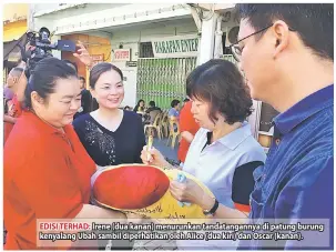  ??  ?? EDISI TERHAD: Irene (dua kanan) menurunkan tandatanga­nnya di patung burung kenyalang Ubah sambil diperhatik­an oleh Alice (dua kiri) dan Oscar (kanan).