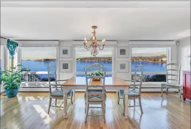  ??  ?? The dining room overlooks the water and has sliders to an exterior deck.