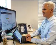  ?? Associated Press ?? ■ Urban Airship product and engineerin­g executive Mike Herrick works at his desk with photos of his daughter, Lauren, and wife Erin at his side in Portland, Ore.