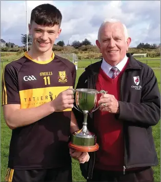  ??  ?? East Kerry Board chairman, Johnny Brosnan, presenting the East Kerry Division 2 Championsh­ip cup to Dr Crokes captain Padraic Looney after they beat Gneeveguil­la in the final in Gneeveguil­la.