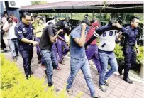  ?? BBXPIX ?? The eight men being led by police personnel at Ipoh magistrate's court.