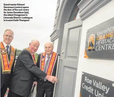  ??  ?? Grand master Edward Stevenson (centre) opens the door of the new centre for James Donaldson (99), the oldest Orangeman in Limavady District. Looking on is trustee Keith Thompson