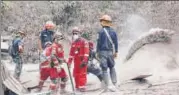  ?? REUTERS ?? Rescue workers remove ash at an area hit by the volcano.