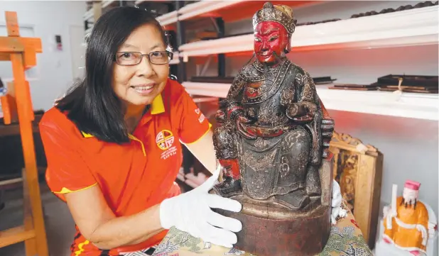  ?? Picture: STEWART McLEAN ?? IN SAFE HANDS: Cairns and District Chinese Associatio­n heritage manager Mary Low with the wooden representa­tion of Kuan Ti, the god of war,