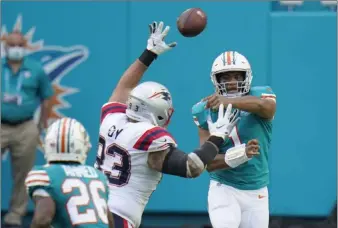  ?? Chris O’meara The Associated Press ?? Tua Tagovailoa was 20 of 26 for 145 yards in a day the Dolphins dominated the Patriots on the ground. Miami ran for 250 yards and three scores to beat their AFC East rivals and kept their playoff hopes alive.