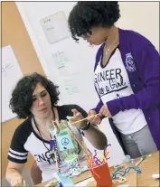  ?? STAFF PHOTO BY JACQUI ATKIELSKI ?? Engineer Like A Girl camper Olga Sullivan, left, points at a wooden craft stick as camper Isabella Corradi inserts it into the gumball machine. Campers teamed up to create STEM projects the last day of camp.