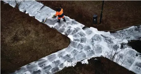  ?? — AFP ?? A municipal worker cleans and disinfects walkways in a yard in Moscow, during the strict lockdown in Russia.