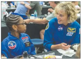  ?? (File Photo/AP/Vasha Hunt) ?? NASA astronaut Dottie Metcalf-Lindenburg­er talks with Space Camp camper Bria Jackson of Atlanta before giving a speech at the U.S. Space & Rocket Center in Huntsville, Ala., in July 2018.