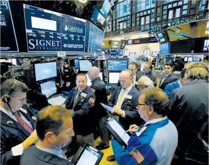  ?? (Andrew Kelly/Reuters) ?? TRADERS WORK on the trading floor at the New York Stock Exchange yesterday. Positive news from China spurred higher openings on Wall Street, but the main stock indexes could not weather political fears as trading wore on.