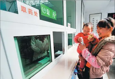  ?? LIU XIAO / XIHUA ?? A woman collects medication prescribed after a free checkup as part of a “Healthy Mother” program launched by Langao county in Shaanxi province.