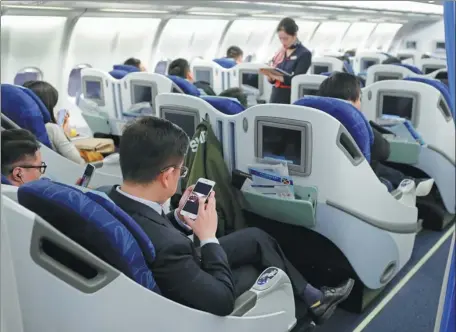  ?? YIN LIQIN / CHINA NEWS SERVICE ?? Passengers use mobile phones in airplane mode on a China Eastern Airlines passenger plane on Jan 18.