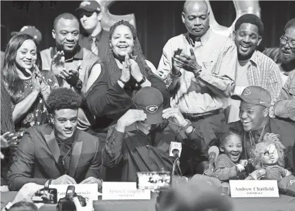  ??  ?? Tyson Campbell of American Heritage High School puts on a Georgia hat after announcing his signing with the Bulldogs. TAIMY ALVAREZ/FLORIDA SUN-SENTINEL VIA AP