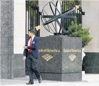  ?? STEPHEN M. DOWELL/ORLANDO SENTINEL ?? A pedestrian strolls by the Bank of America building in Orlando on Thursday, soon after police rushed inside to investigat­e a bomb threat.