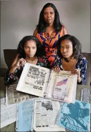  ?? CURTIS COMPTON / CCOMPTON@AJC.COM ?? Angela Greene-Johnson connected her daughters, Sharena (left) and Malia Johnson, both 17, with informatio­n about her father’s family in Mississipp­i when the twins worked on their civil rights family heritage project in 2011.