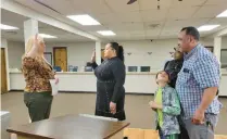  ?? MICHELLE L. QUINN/POST-TRIBUNE ?? Lake County Election Board Director Michelle Fajman, left, swears in Marian Ivey as Gary’s new at-large councilwom­an as her family — parents Janis and Darryl Redmond and brother Keon Redmond, 8 — watch on Saturday. Ivey won in the fourth round of voting during a caucus to replace Ron Brewer Jr., who vacated the seat to assume the First District Lake County Council seat for the late Clorius Lay.