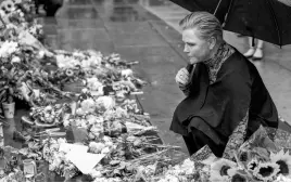  ?? NTB • BEATE OMA DAHLE VIA REUTERS ?? Norway’s Minister of Developmen­t Anne Beathe Tvinnereim visits the memorial site following the recent deadly mass shooting at a gay bar in Oslo, Norway, on June 27.