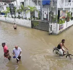  ?? ?? COLOMBO: People wade through a flooded street yesterday. —AP