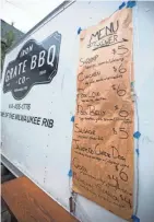  ?? TYGER WILLIAMS, MILWAUKEE JOURNAL SENTINEL ?? The menu for Iron Grate BBQ's food truck, parked on the patio behind Lost Whale from Thursday to Sunday, is written on butcher paper. Save for a sausage served on a bun, everything is grilled on skewers.