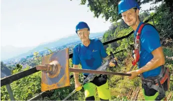  ?? BILD: SN/ANTON PRLIC ?? Vitus Danklmayr und Bernd Zörweg von der Firma Felbermayr befestigen die Metallstan­gen im Fels.