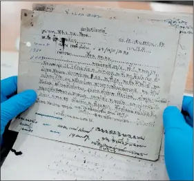  ?? (File Photo/AP/Sakchai Lalit) ?? Retired Thai Air Chief Marshal Sakpinit Promthep looks at a World War II-era local Thai police report April 29 in the archive room of the Thai Air Force Museum in Bangkok.