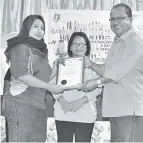  ??  ?? NUR Aisyah menerima sijil penghargaa­n disampaika­n Abidin.