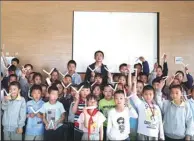  ??  ?? Qiang and his students show their origami works after an art class in the middle school where he works.