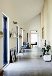 ??  ?? HALLWAY
The guest bedrooms lead off from a corridor that runs the length of the building, which has a polished concrete floor. Inset shelving on the right provides a place to display favourite ceramics, while floating shelves on the left house artworks by local artists