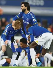  ?? — AFP ?? Everton’s Demarai Gray (centre) celebrates with teammates after scoring against Arsenal during their English Premier League match in Liverpool on Monday.