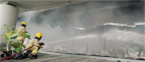  ?? Photo: Felix Wong ?? Firefighte­rs battle the blaze in a building beneath the flyover at Tsuen Wan that led to two workers being injured and the road above temporaril­y closed to traffic.