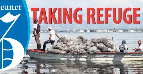  ?? PHOTOS BY CHRISTOPHE­R SERJU ?? Their boat laden with another load of garbage collected from Refuge Cay, the crew prepares to head for the mainland.