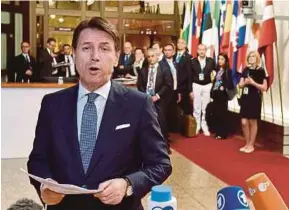  ?? REUTERS PIC ?? Italian Prime Minister Giuseppe Conte talking to reporters as he leaves a European Union leaders summit in Brussels, Belgium, yesterday.