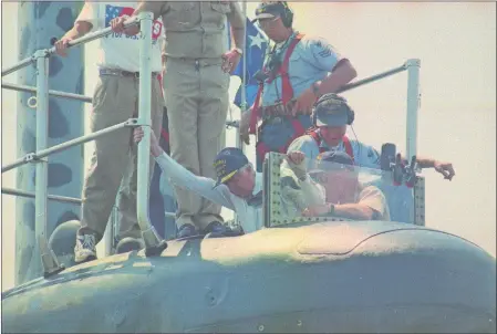  ?? DAY FILE PHOTO ?? Above, former President Jimmy Carter climbs out of the USS Seawolf (SSN-21) after a trip aboard the submarine at the Naval Submarine Base in Groton on July 27, 1998. Below, Carter, second from left, then a Navy lieutenant, peers at instrument­s on the USS K-1 in 1952.