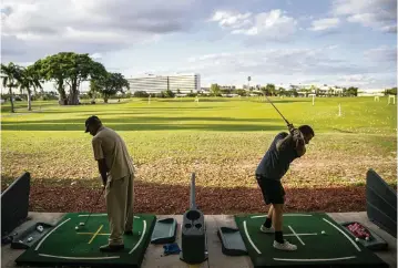  ?? MATIAS J. OCNER mocner@miamiheral­d.com ?? Nicholas Cavell, 28, right, of Kendall,
practices Wednesday at the Melreese
driving range.