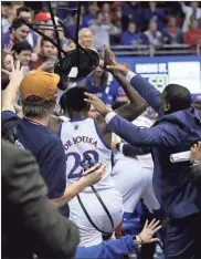  ?? AP - Orlin Wagner ?? A Kansas assistant reaches to take a stool out of the hands of the Jayhawks’ Silvio De Sousa during Tuesday’s late-game confrontat­ion with rival Kansas State.