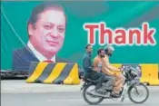  ?? AFP ?? Pakistani men on a motorcycle ride past a banner in Islamabad featuring the portrait of Prime Minister Nawaz Sharif.