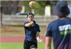  ??  ?? Kate Price handballs with Lions player Zac Bailey at the Community Camp.