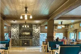  ?? ?? The cozy lobby of the Wallowa Lake Lodge features a roaring fireplace and plenty of green velvet couches.