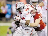  ?? AP/AJ MAST ?? Ohio State quarterbac­k J.T. Barrett (left) is tackled by Wisconsin’s Ryan Connelly during the Buckeyes’ 27-21 victory over Wisconsin in the Big Ten championsh­ip game Saturday night in Indianapol­is.