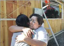  ??  ?? MARICELA PEÑALOZA FLORES, Albino’s wife, embraces a family member during a Mass for her slain husband.