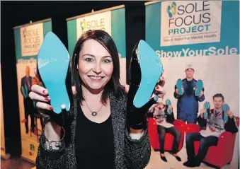  ??  ?? Liz Farano, vice-president of the Douglas Marketing Group, shows off her blue soles as part of the Sole Focus Project launched Wednesday by the CMHA’s Windsor-Essex County Branch at the WFCU Centre.