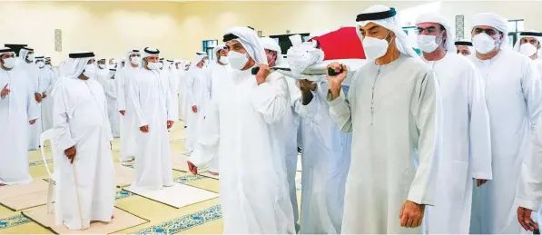  ?? WAM ?? ■ Shaikh Mohammad Bin Zayed Al Nahyan and Shaikh Mansour Bin Zayed Al Nahyan carry Shaikh Khalifa’s body during the funeral prayers at Shaikh Sultan Bin Zayed The First mosque in Abu Dhabi.
■ Left: UAE Honour Guard pallbearer­s carry Shaikh Khalifa’s body to Shaikh Sultan Bin Zayed The First mosque for funeral prayers.