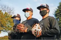  ?? JONATHAN ZIZZO/THE NEW YORK TIMES ?? Strangers bring masks, gloves and a desire for simple pleasure to a game of catch at Cole Park in Dallas in Jan. 13. Alice Miller’s social media posting seeking a pitch-and-catch partner for her husband yielded an unexpected outpouring.