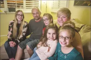  ?? Austin Dave/The Signal (See additional photos on signalscv.com) ?? (Above) The Hughes family poses for a photo in their living room in January 2018. (Below) Cheyenne Hughes plays with her sisters in their home. Hughes pulled through a 10-hour surgery about one year ago to remove a tumor found by her brain. She now...