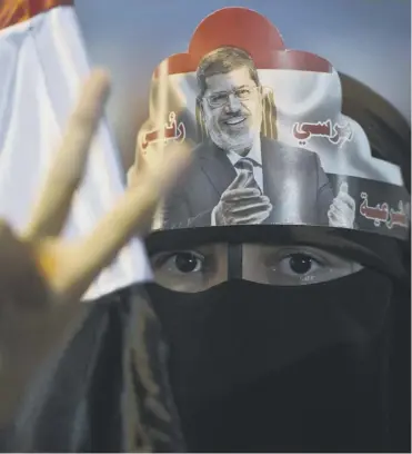  ?? Picture: Getty ?? a woman wears her support for Mr Morsi on her head in a sit–in at rabaah al–adawiya mosque